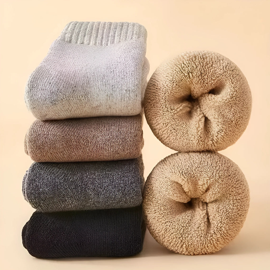 Two pairs of thick, solid-colour winter wool socks in a box, shown in khaki and dark grey.