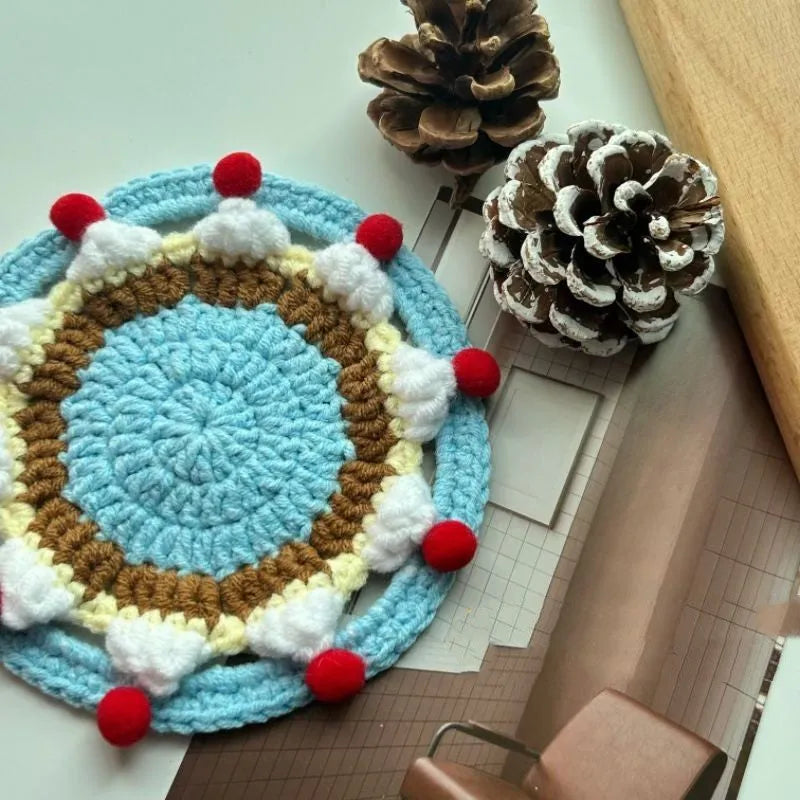 A single 9cm round wool coaster and its decorative cake-themed storage bag.