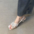 Retro beige high heel sandals with thin cross straps, an ankle buckle, and a square toe on a rubber sole.