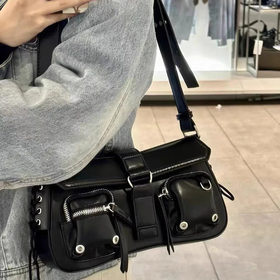 Black women's underarm baguette bag with adjustable shoulder strap showing internal zippered change compartment