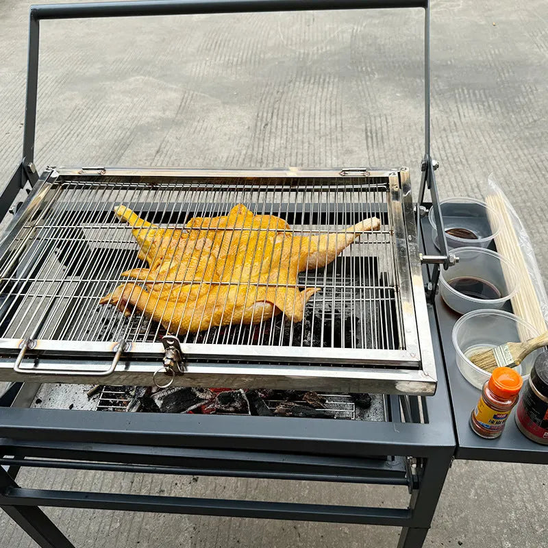 Large foldable charcoal BBQ stove with grill, shown in an outdoor setting.