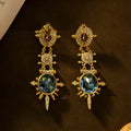A pair of gold retro-style stud earrings with a geometry shape and round design elements.