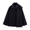 Women's long grey overcoat with a fluffy artificial fur collar, styled in a street fashion setting.