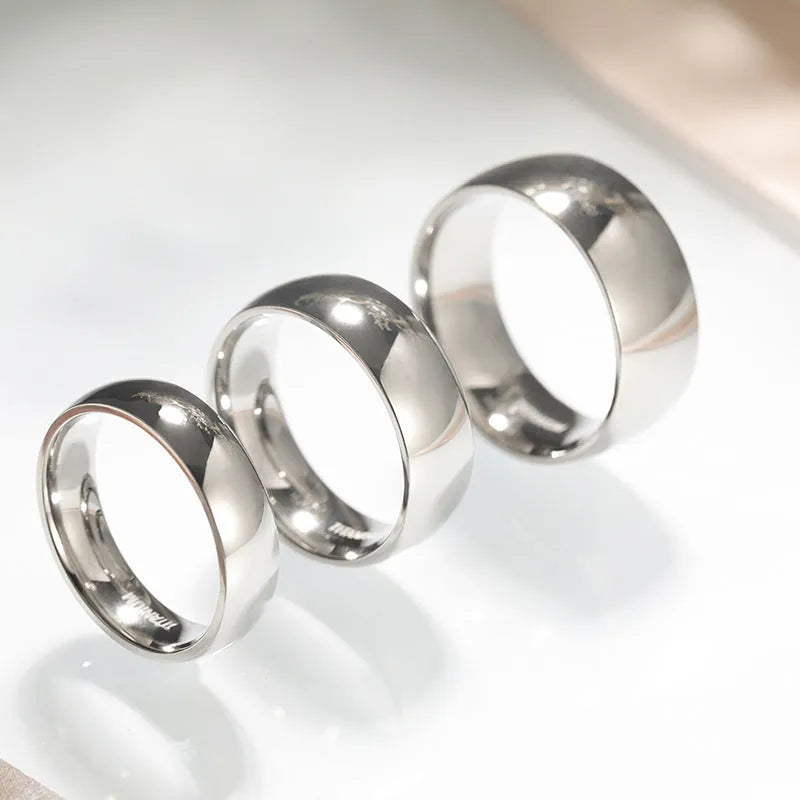 Silver coloured titanium steel unisex ring shown in 2mm, 4mm, and 6mm band width options.