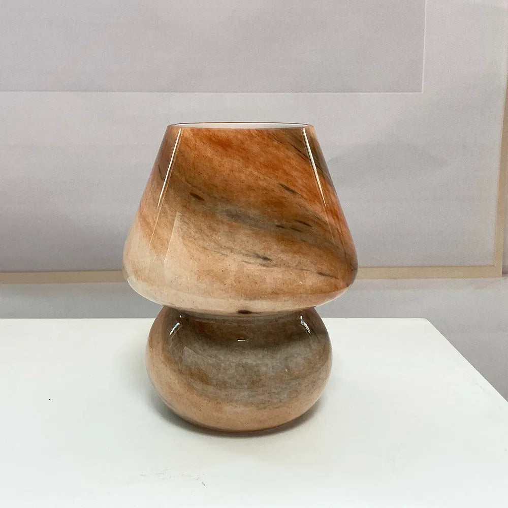 Handmade glass mushroom table lamp in Earth colour on a wooden bedside table with a soft glow