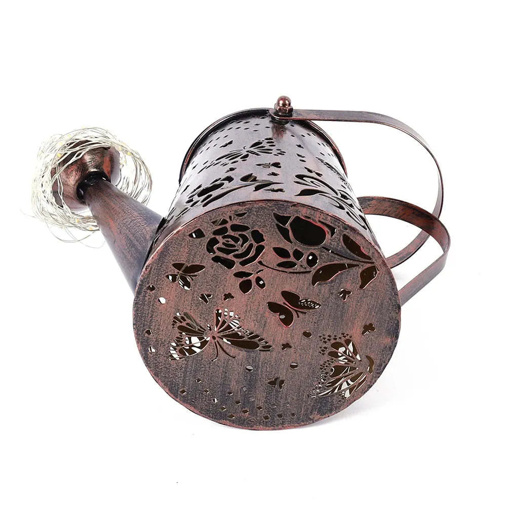 Solar-powered iron garden lamp with a tapered butterfly design emitting warm white LED light.