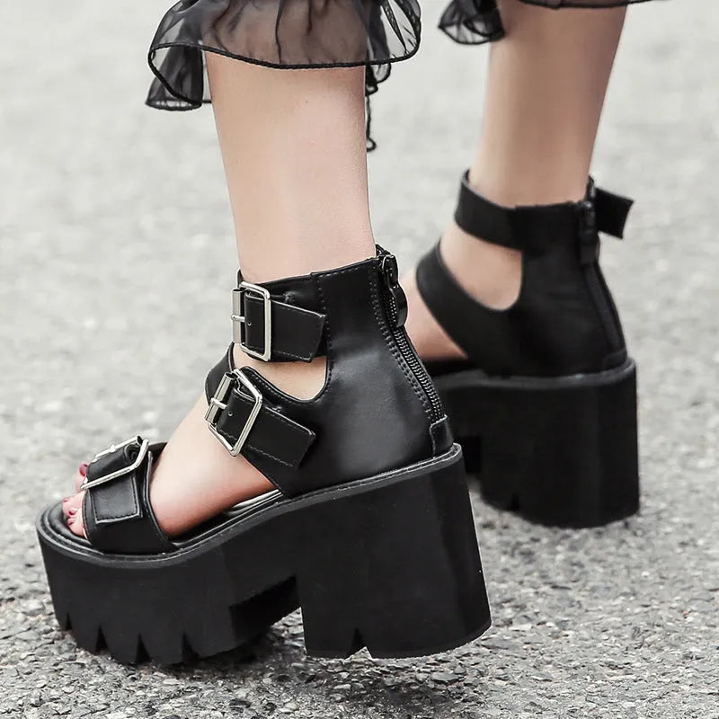 Black punk-style women's sandals with a thick chunky heel, round toe, buckle detail and back zipper.