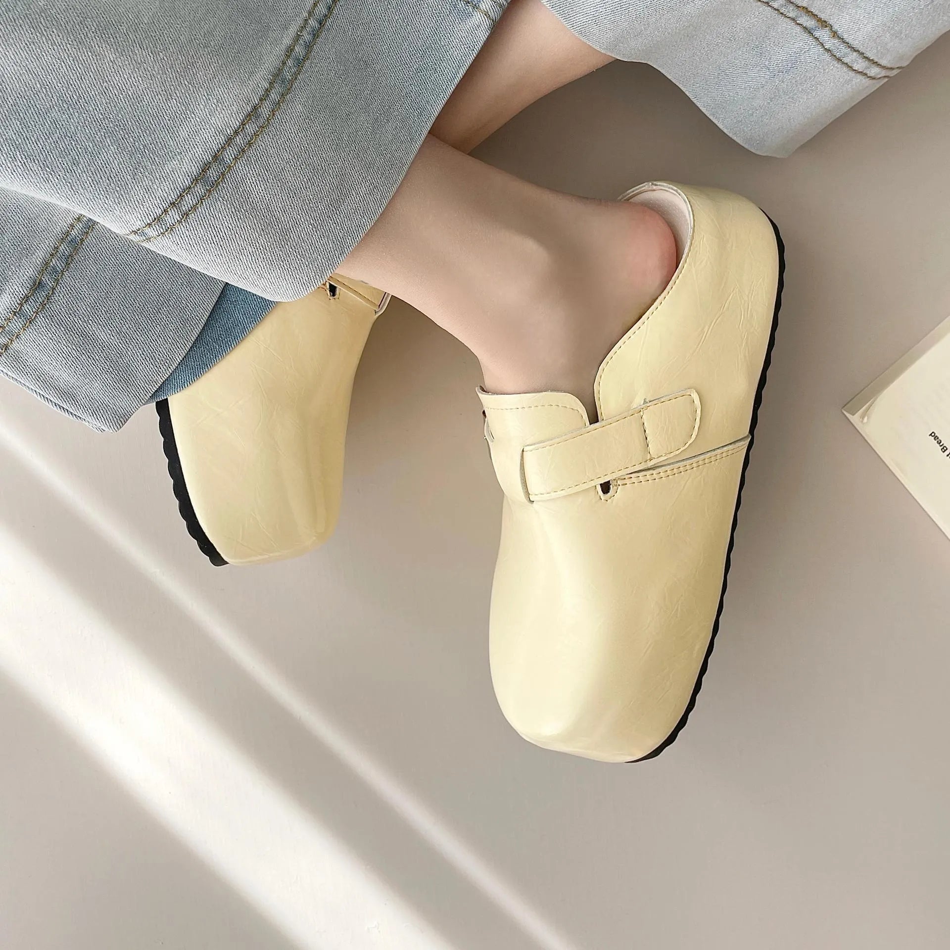Flat round-toe casual sneakers with a metal buckle on the PU upper.