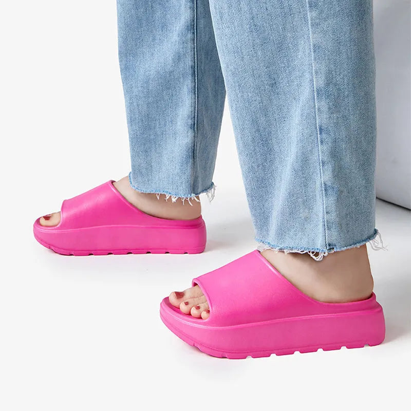 Women's beige fish mouth style slippers with a thick EVA sole on a wooden floor.