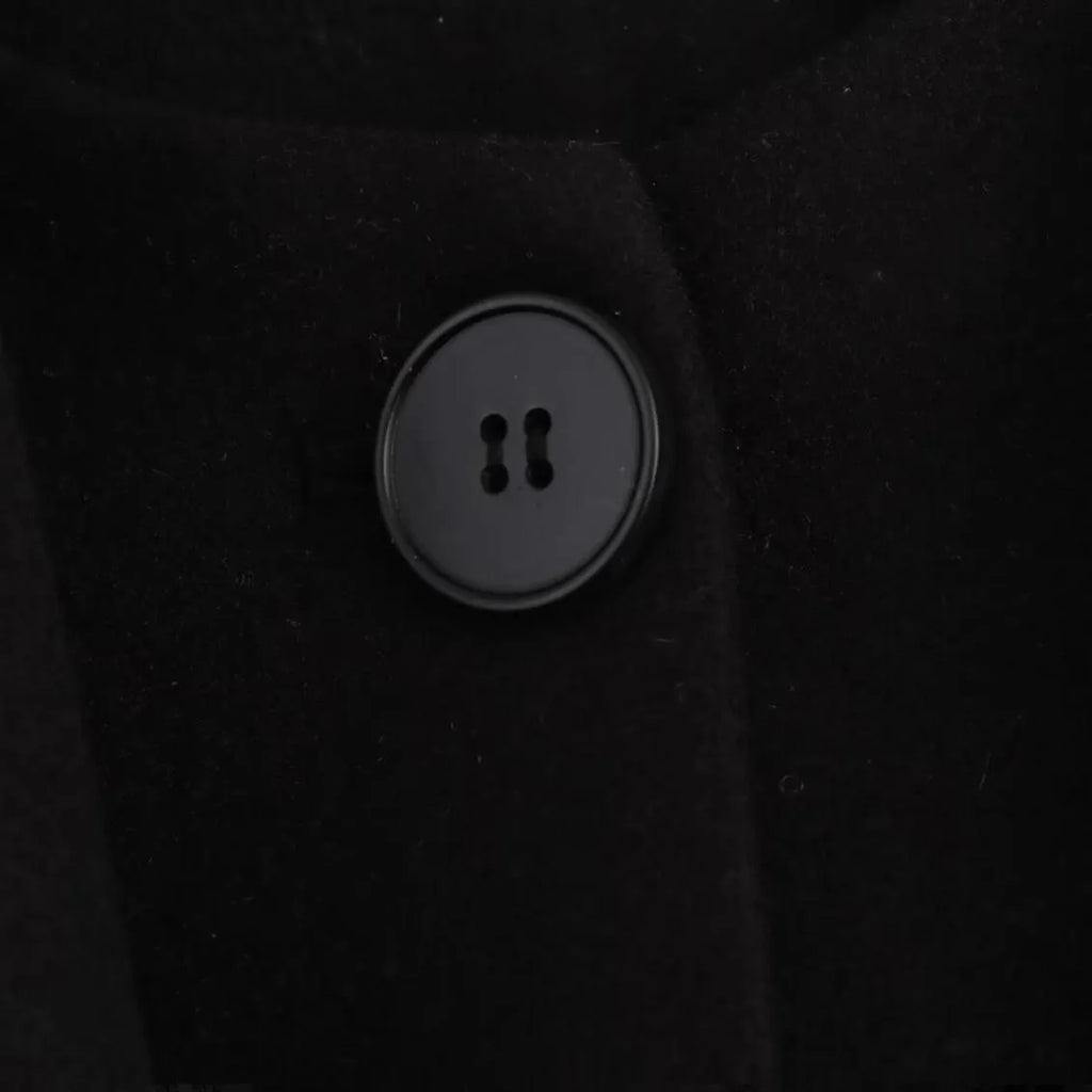 Women's long grey overcoat with a fluffy artificial fur collar, styled in a street fashion setting.