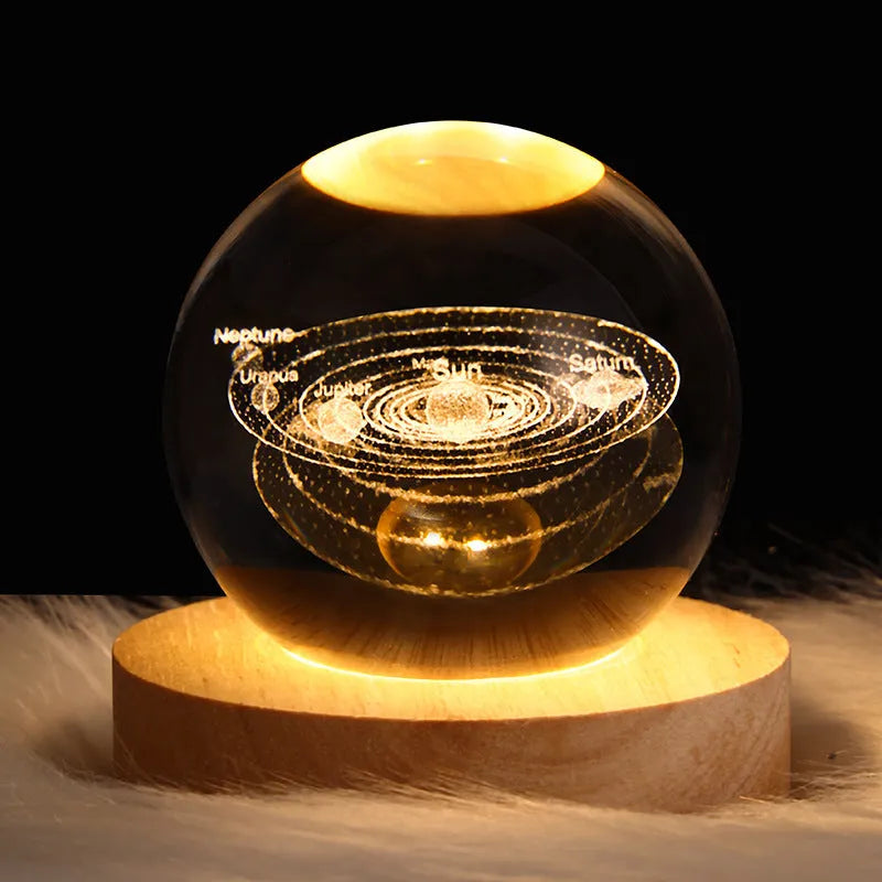 LED galaxy crystal ball night light with 3D planet designs on a table