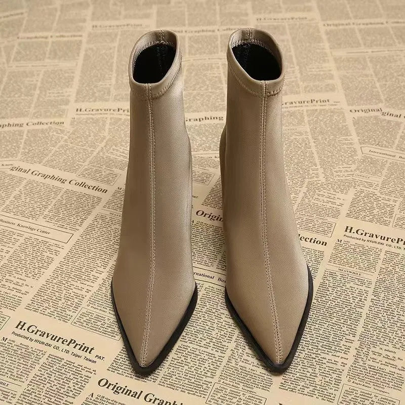 Women's khaki pointed-toe Martin boots with a wedge heel on a plain background.