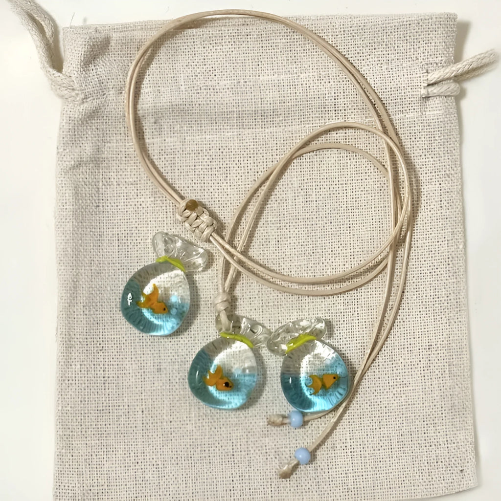 Women's necklace with coloured glaze joker pendant on a beige cotton linen clavicle chain.