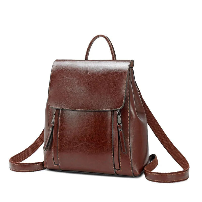 Large genuine cowhide leather women's backpack in black, shown with open cover to reveal internal zipper pockets and phone sleeve.