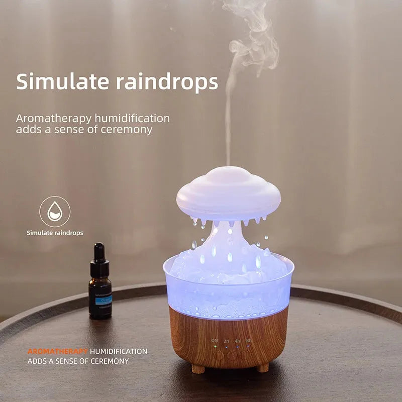 Wood grain white rain cloud-shaped ultrasonic humidifier diffuser with LED lights on a table.