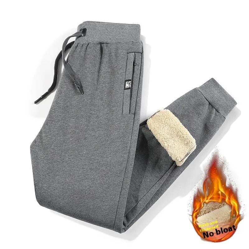 Man wearing grey fleece-lined oversized cotton track pants with a drawstring waist.