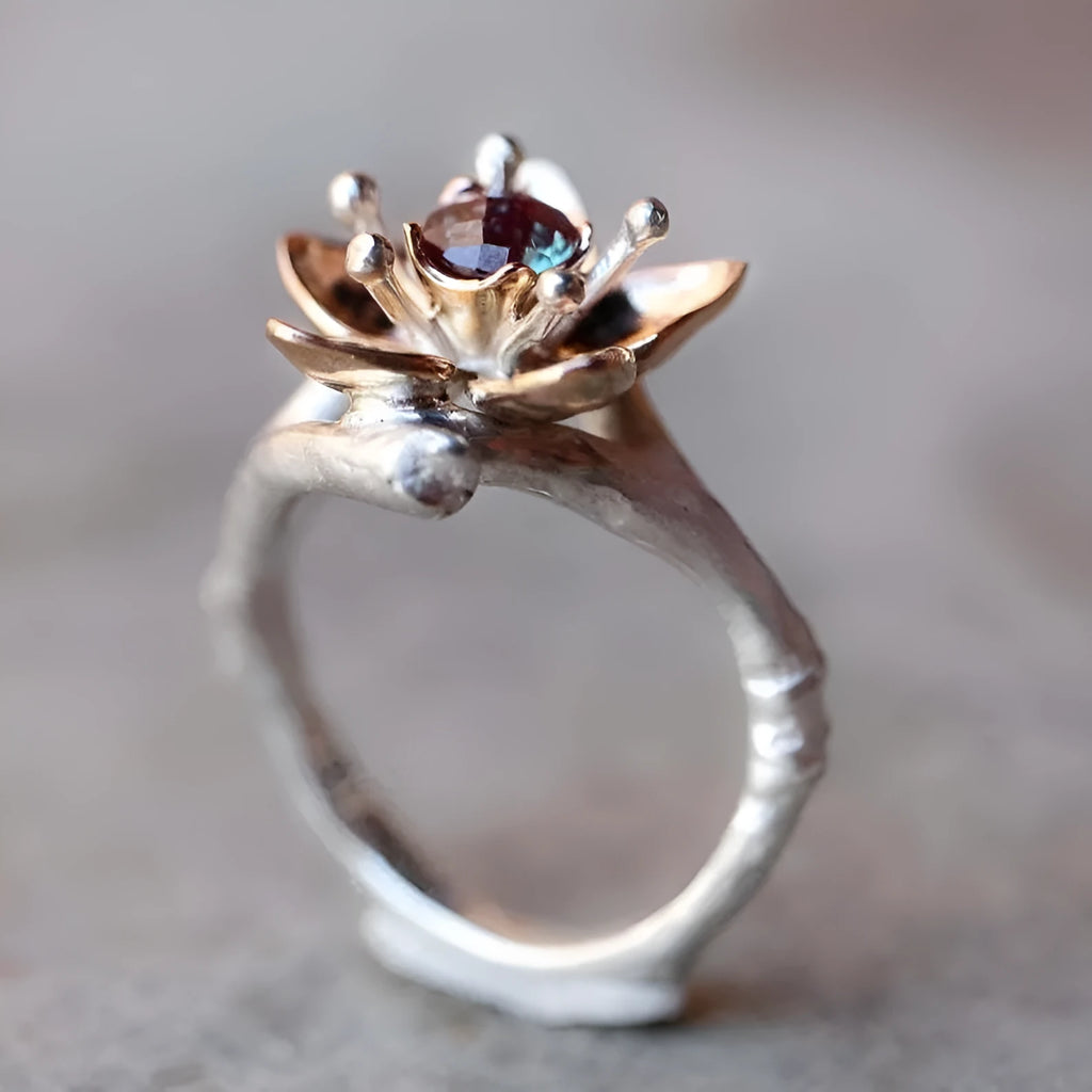 Silver two-tone women's alloy ring with a geometric floral design on a plain background.