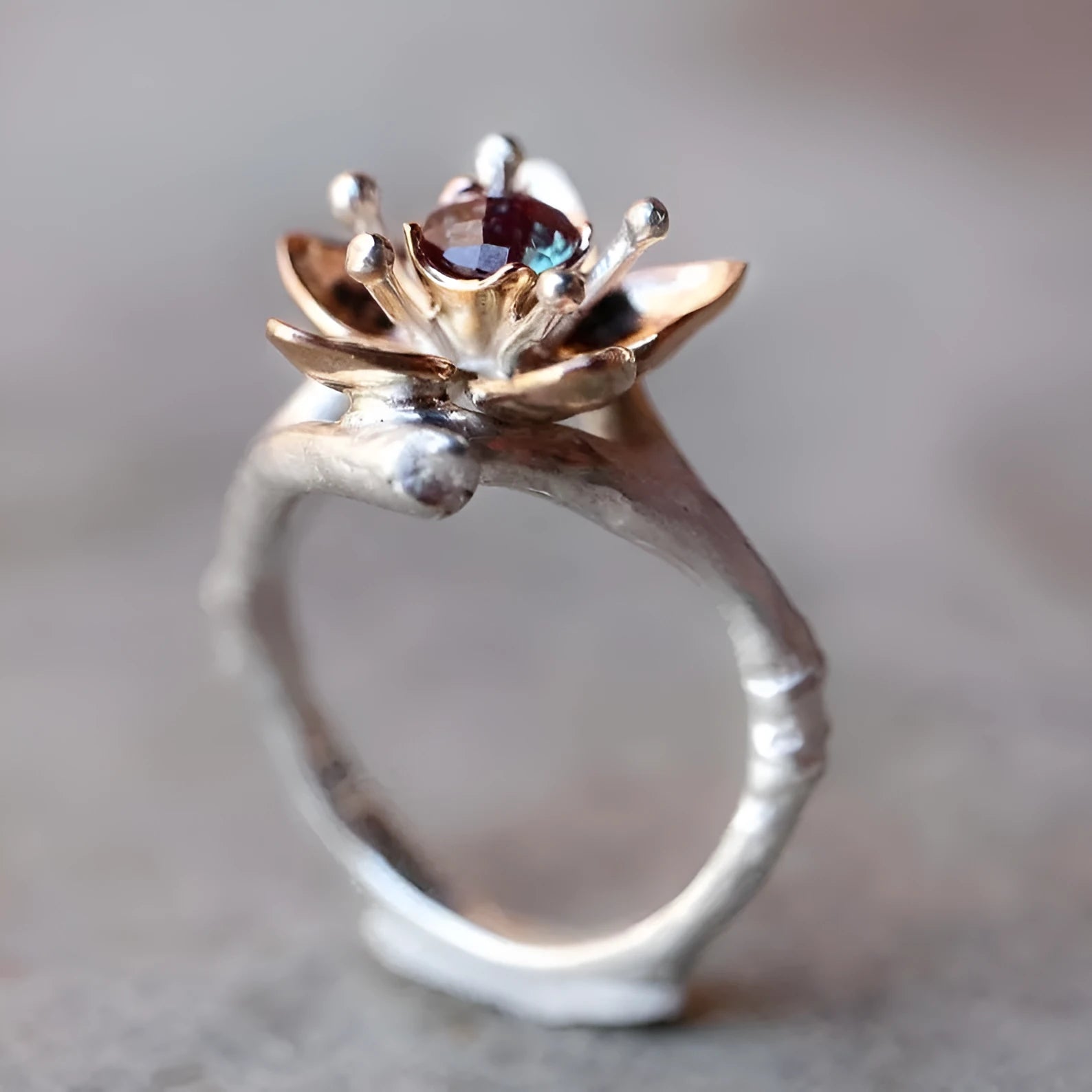Silver two-tone women's alloy ring with a geometric floral design on a plain background.