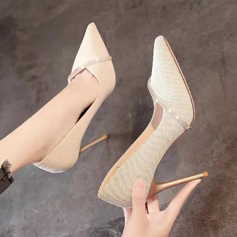 Women's black stiletto high heels with pointed toe and oversleeve design on a white background.