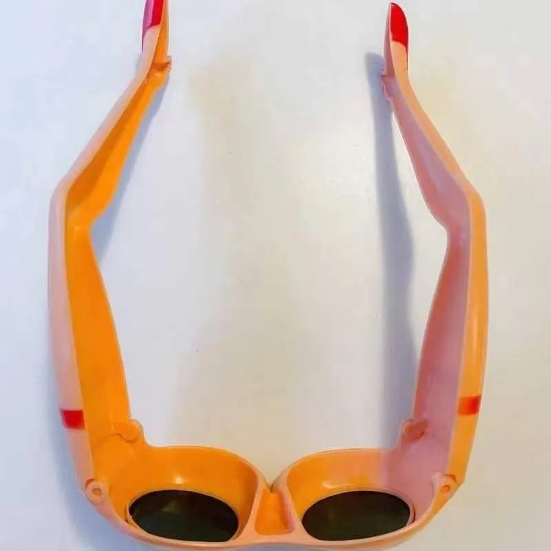 Orange novelty sunglasses with a unique leg hip style design on a white background.
