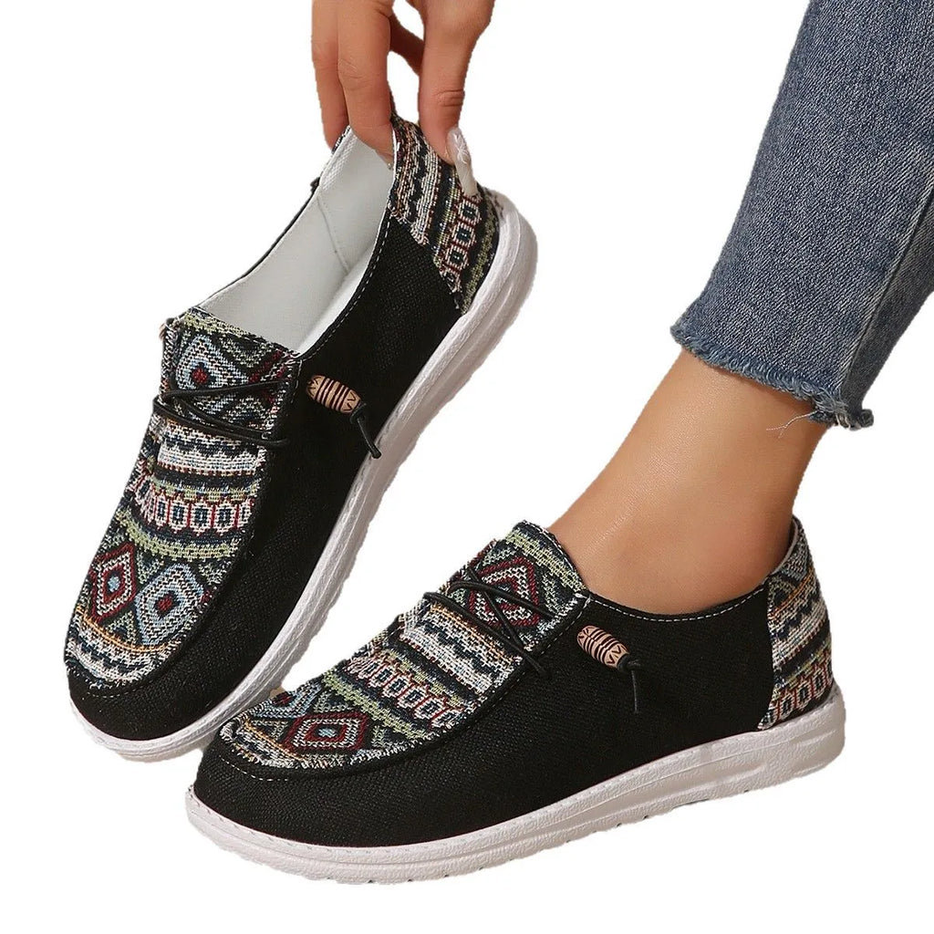 Women's low-top flat shoes in black with round toe and rubber sole, shown from the side.