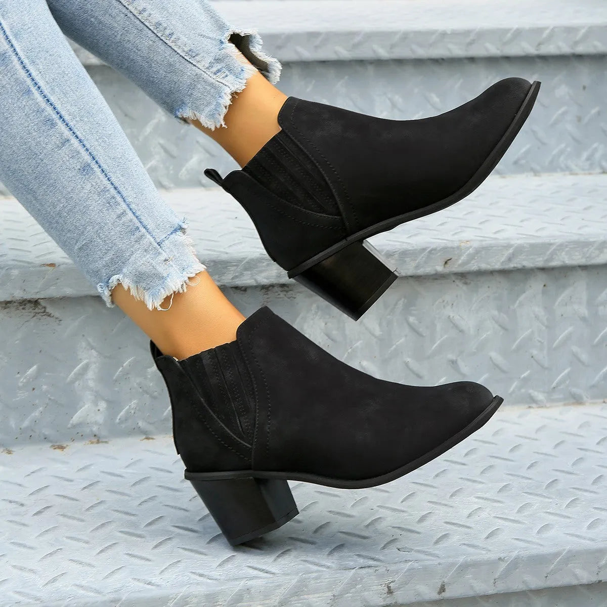 Black women's ankle boot with pointed toe and thick square low heel, slip-on design