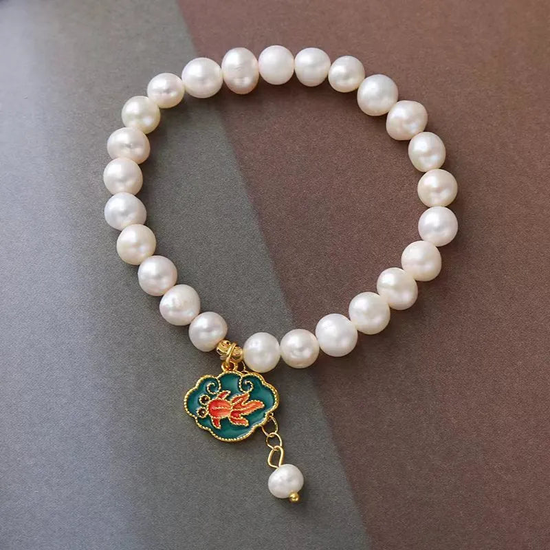 White vintage baroque bracelet with a freshwater pearl and goldfish lotus pendant.