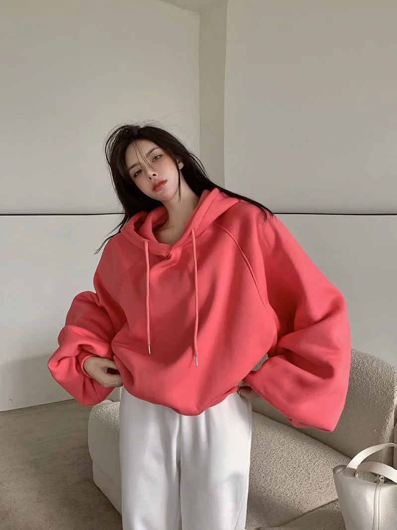 Watermelon red women's sleeveless silk hooded sweater on a hanger showing loose fit and hood detail.