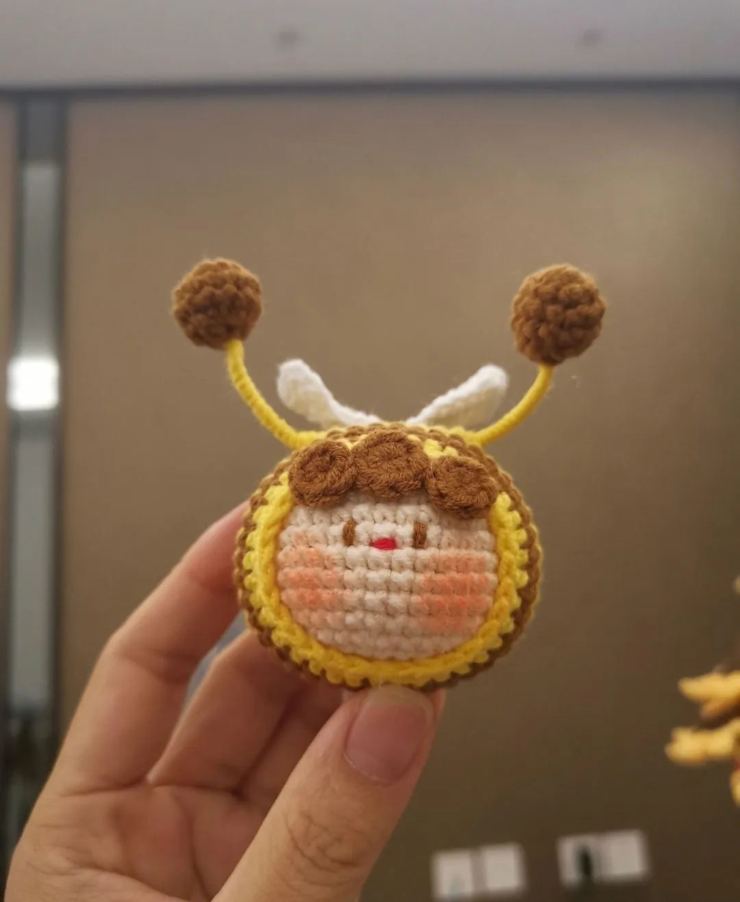 Handmade crocheted plush bee hive and bees accessory for woolen dolls on a white background.