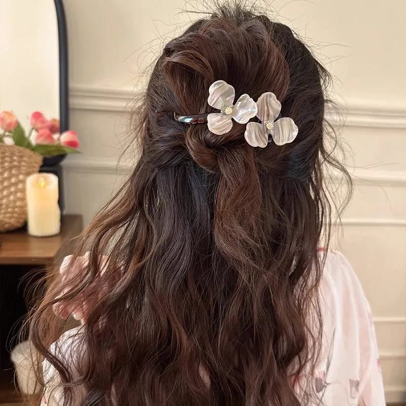 Close-up of a retro-style floral bobby pin with coloured acrylic petals.