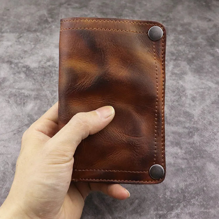 Men's brown leather bifold wallet open showing multiple card slots and coin pocket