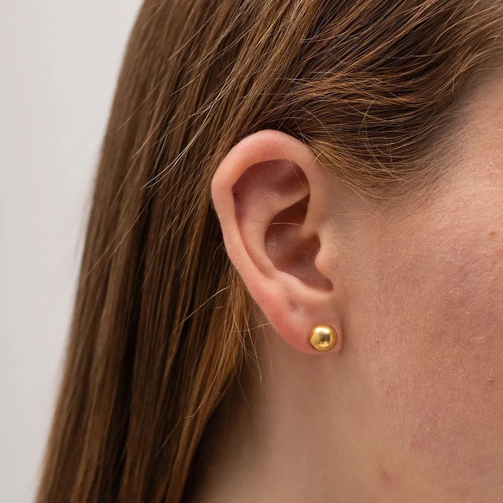Stainless steel minimalist ball stud earrings with a round geometric shape, shown in various sizes.