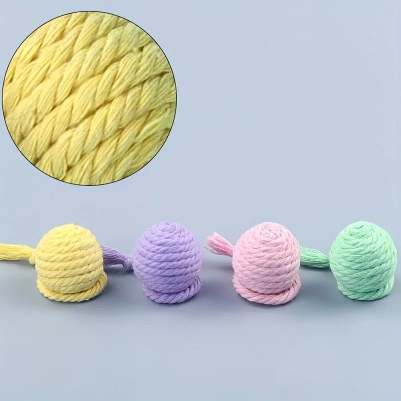 Colourful cat toy ball with an attached rope and built-in bell for kittens, shown in green, pink, purple, and yellow.