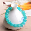 Selection of polished blue-green Amazonite scattered beads in different sizes for making a crystal bracelet.