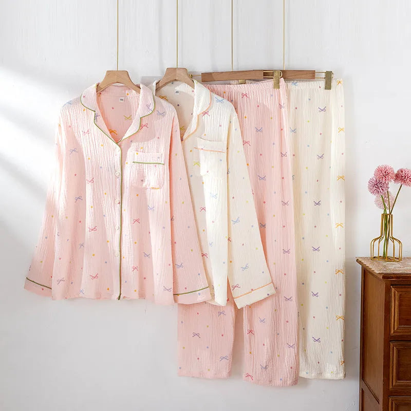 Women's pink cotton pajama set with long sleeves and trousers, laid flat.
