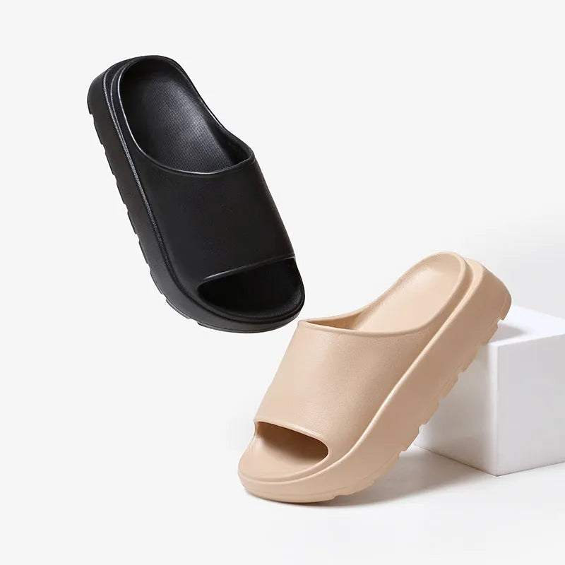 Women's beige fish mouth style slippers with a thick EVA sole on a wooden floor.