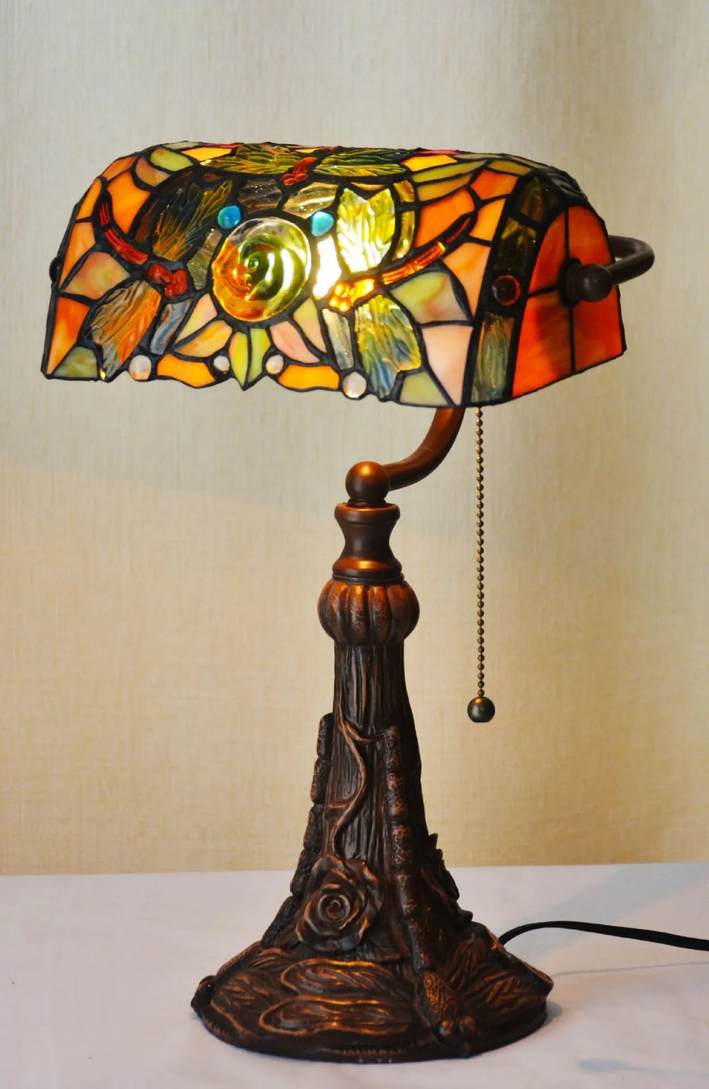 10-inch Tiffany stained glass table lamp on a desk with a warm glow.