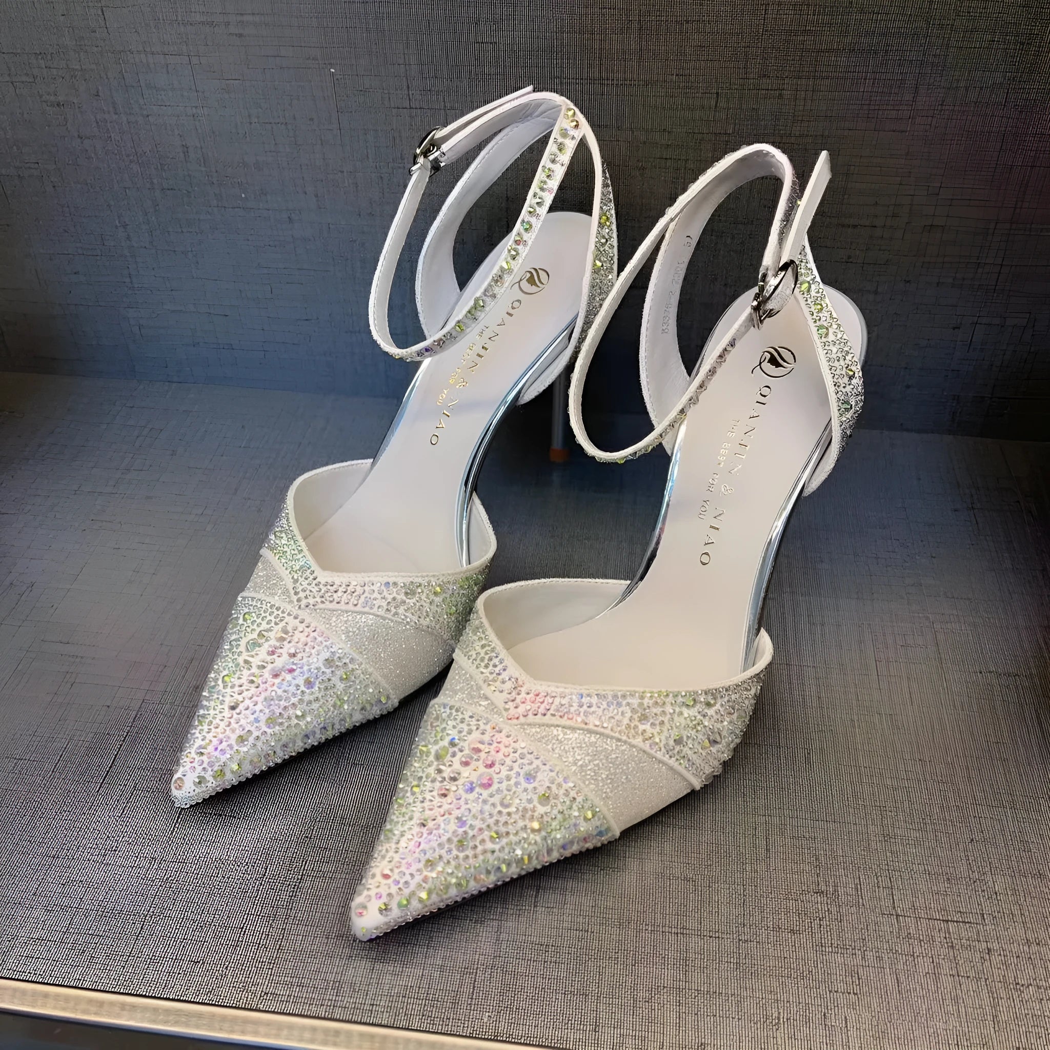 Women's black high-heeled shoes with a red sole, showing stiletto heel and pointed toe design.