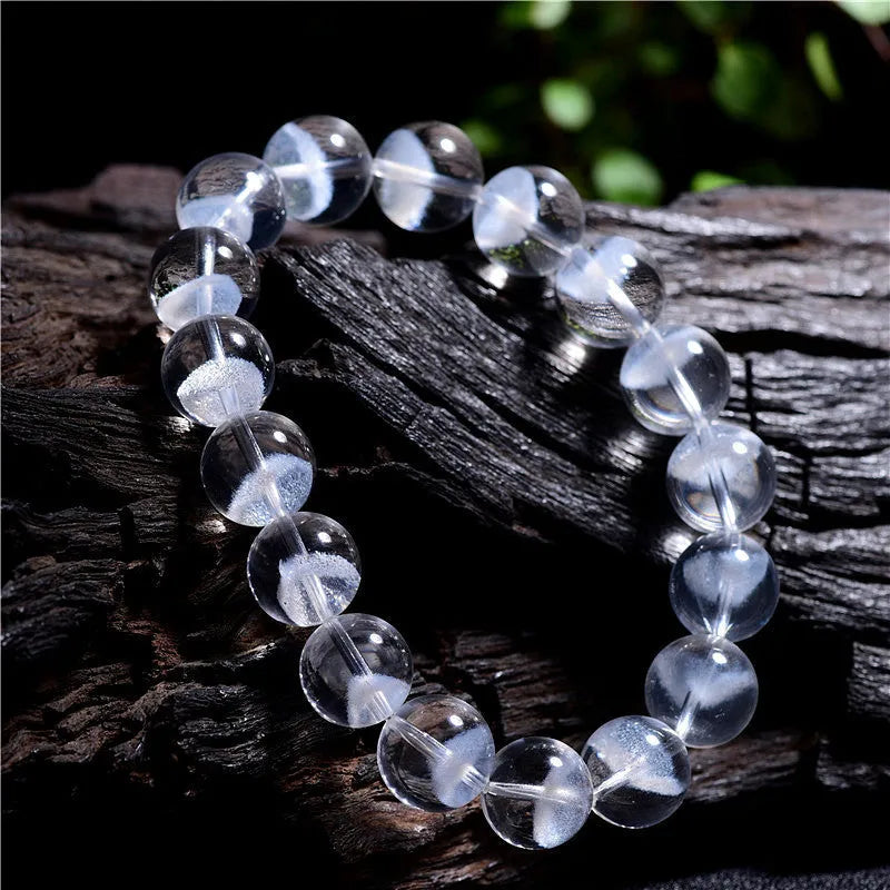 Women's white crystal pyramid bracelet with Ruyi symbol, showing polished beads.