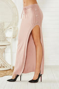 Black slim-fit midi skirt with a side split and strap details on a mannequin.