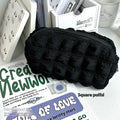 Beige and black fabric cream puff style pencil case made from polyester.