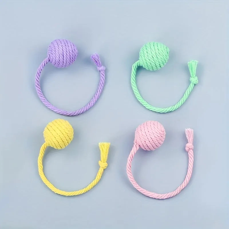 Colourful cat toy ball with an attached rope and built-in bell for kittens, shown in green, pink, purple, and yellow.