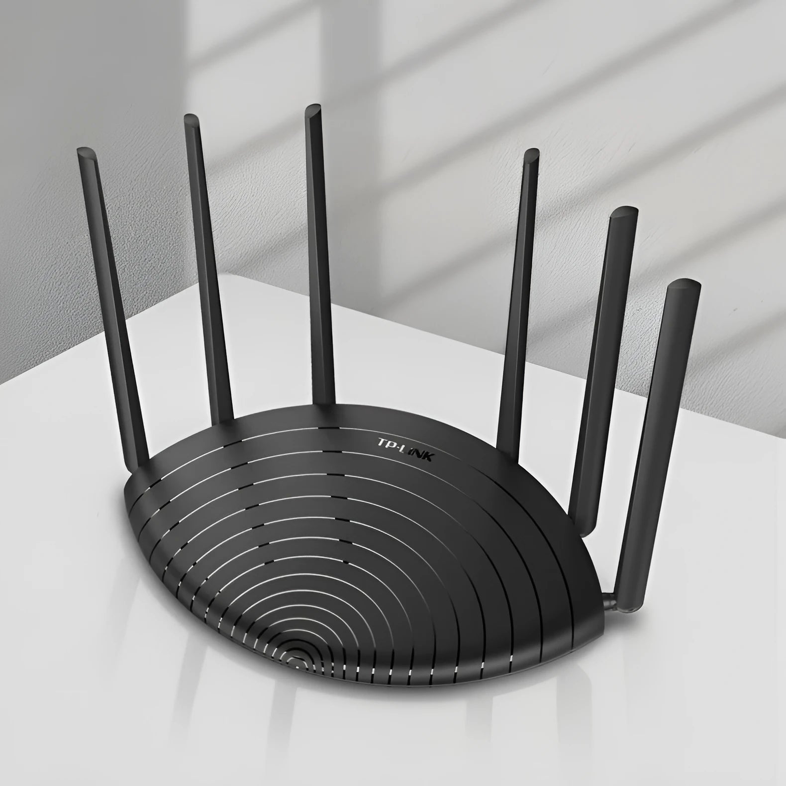 TP-Link TL-WDR7661 black AC1900 gigabit wireless router with fixed antennas on a desk.