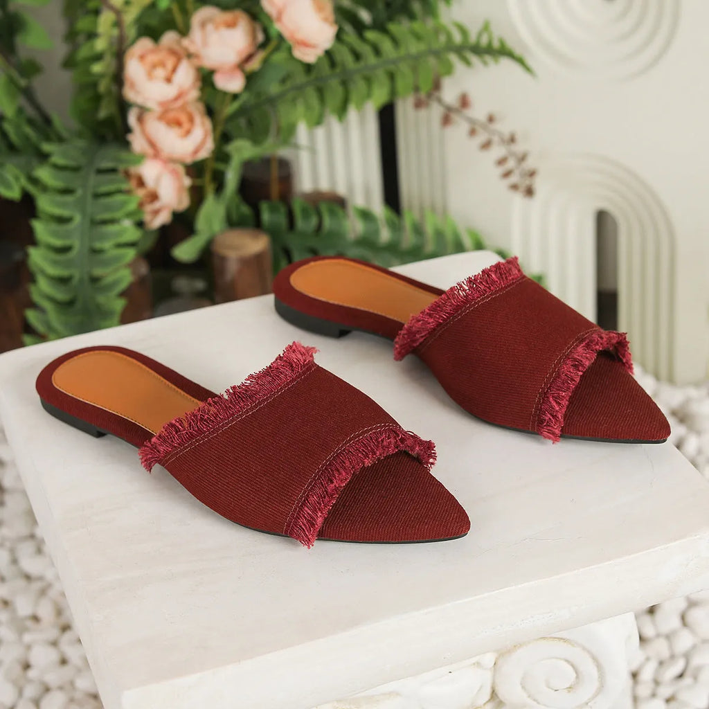 Women's apricot denim flat slippers with a tassel detail and leather lining.
