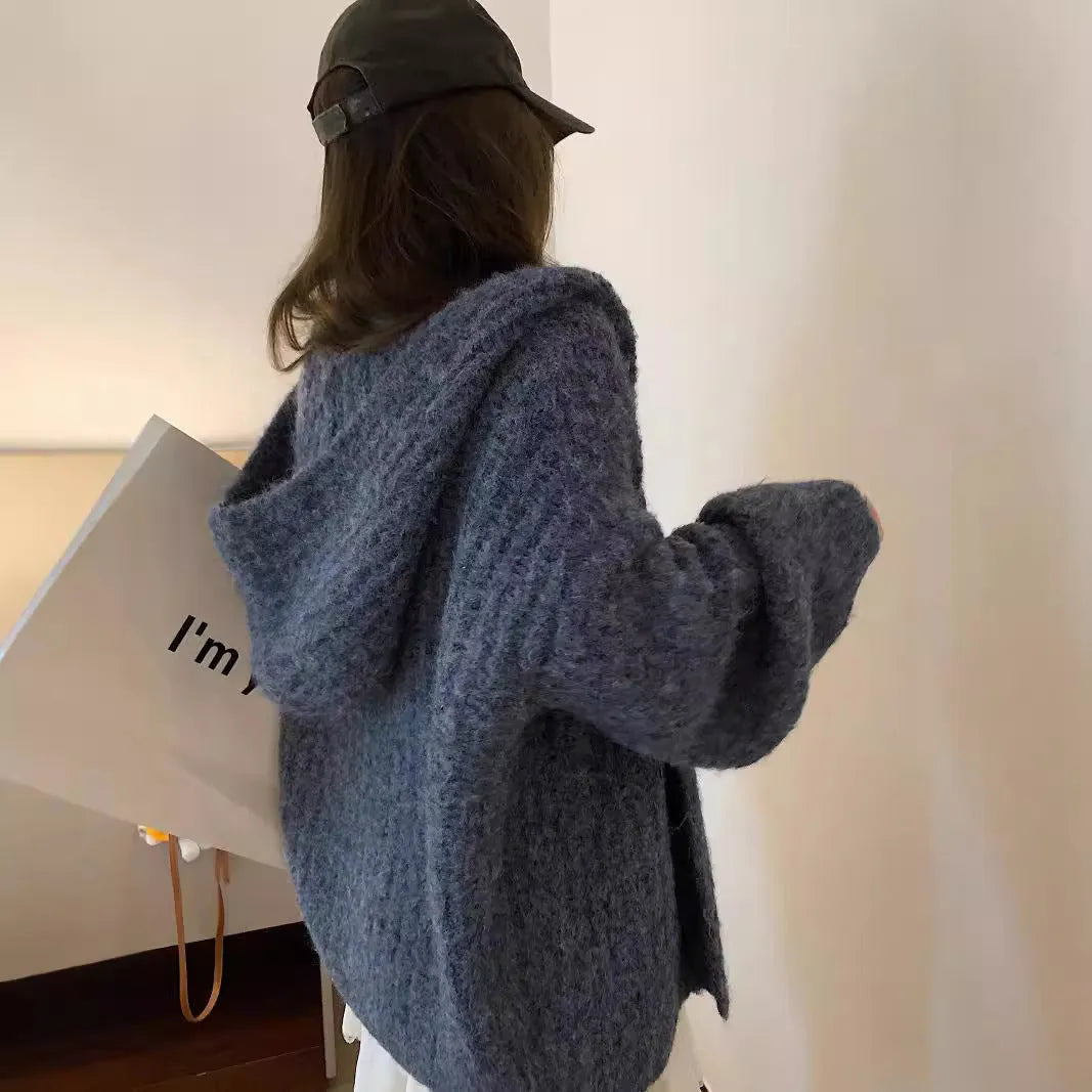Women's loose grey hooded cardigan with a thick knit and oversized fit on a hanger.