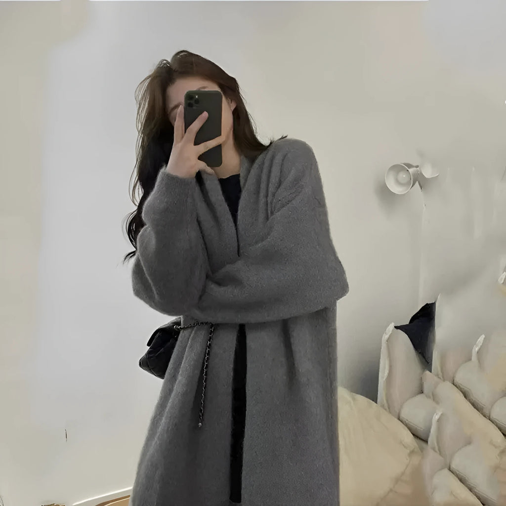 Woman wearing a loose, thick-knit chenille cardigan in a solid colour, showing the long sleeves and casual fit.