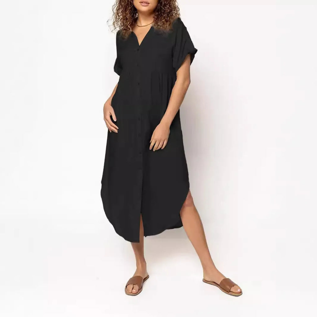 A woman wearing a loose-fitting, solid-colour midi dress with a button-down front and regular sleeves.