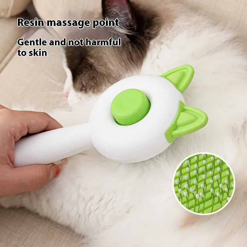 Greenish white cat grooming brush with stainless steel teeth and a self-cleaning button on the handle.