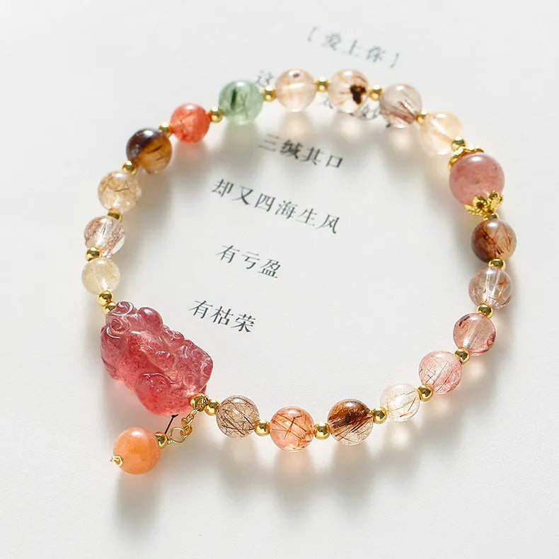 Women's copper bracelet with strawberry quartz crystal, Pixiu charm, and pearl beads.