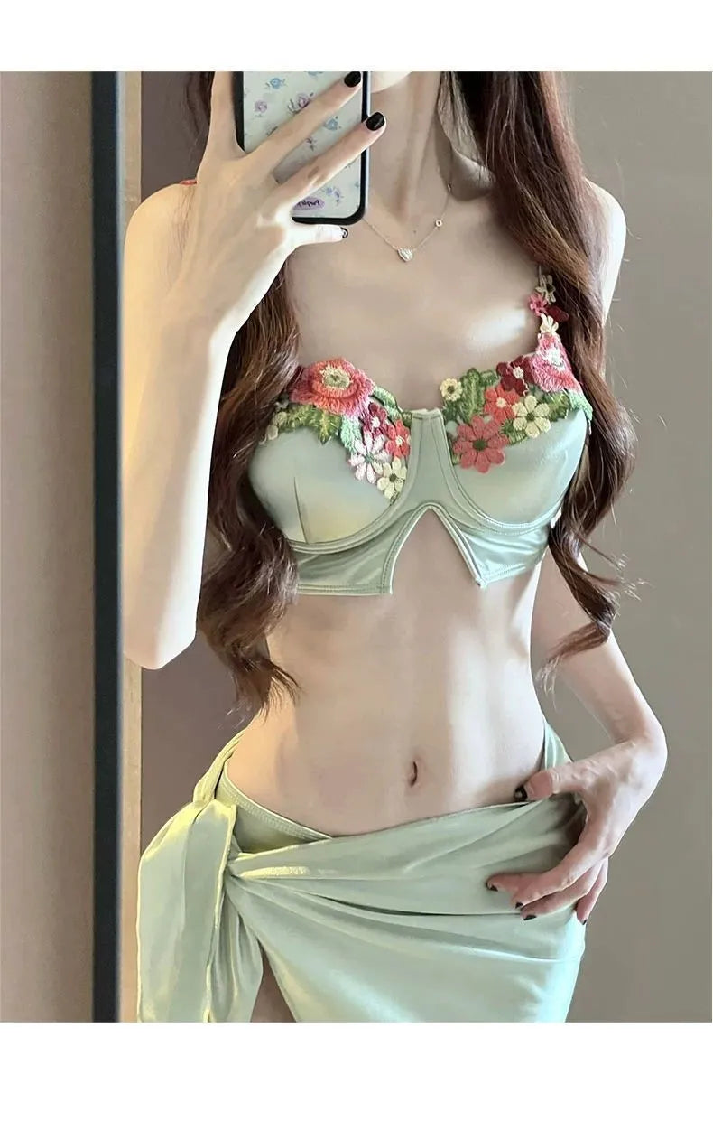 Green women's bikini three-piece set with triangle top, briefs, and matching skirt